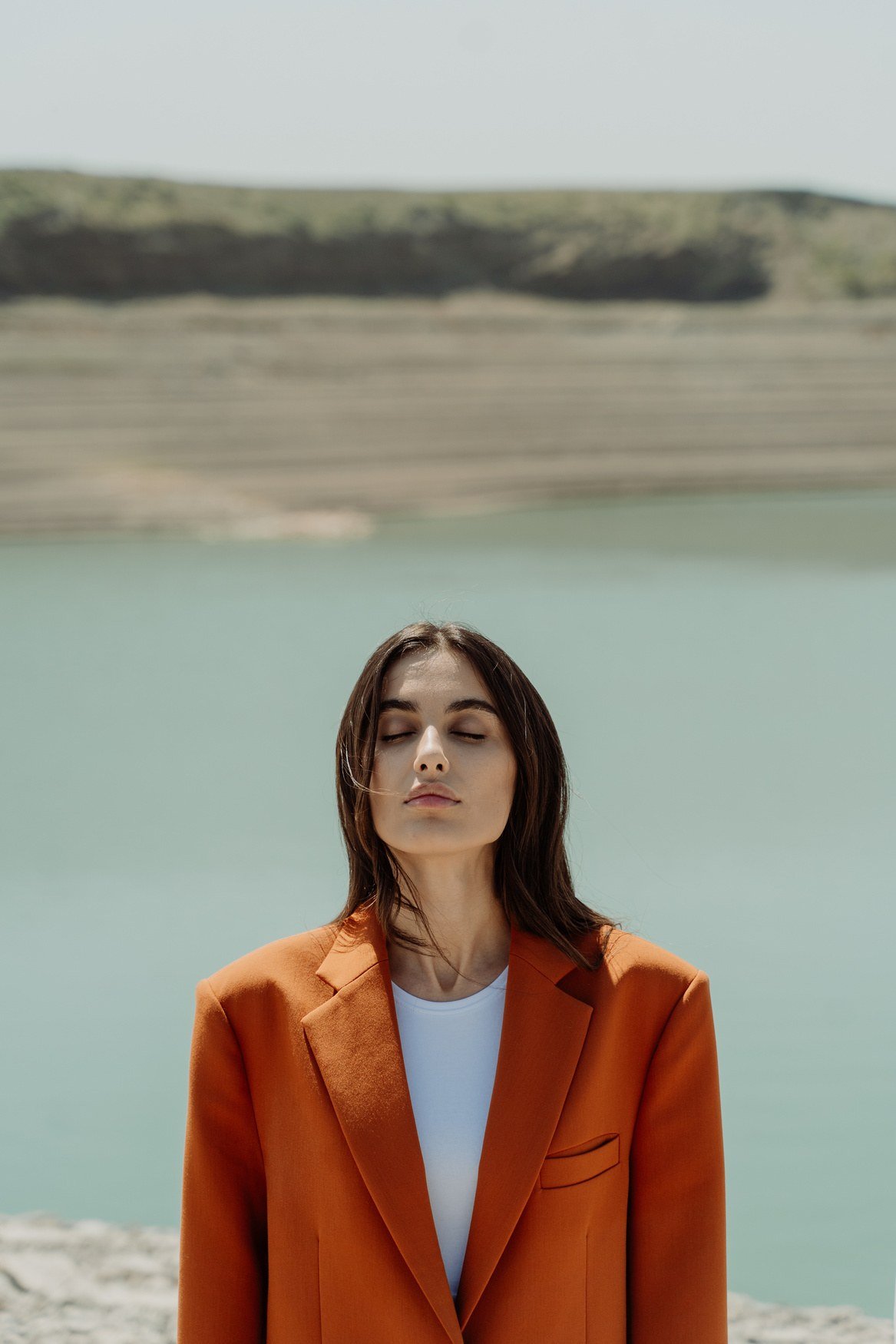 AUREA portrait — rust blazer by the water